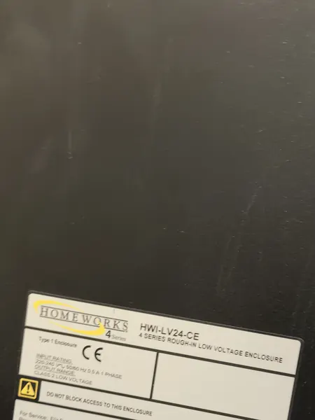 The older Lutron system's black enclosure, its label naming HomeWorks 4 Series and a 4 Series rough-in low voltage enclosure