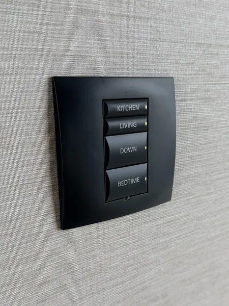 Glowing buttons for the kitchen, the living area, down and bedtime on a keypad set in pale grey wallpaper