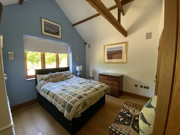 Finished bedroom with a roller blind at the window and the wall controls next to it