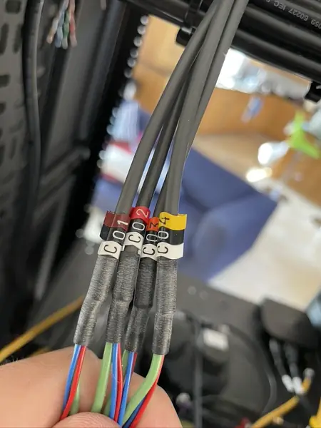 Four control cables tagged C01, C02, C03 and C04 under heat shrink sleeves