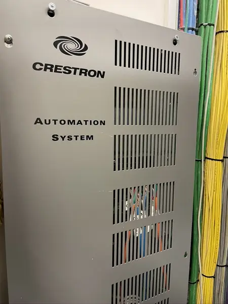 Open grey enclosure marked Crestron Automation System, with control modules and their cables inside