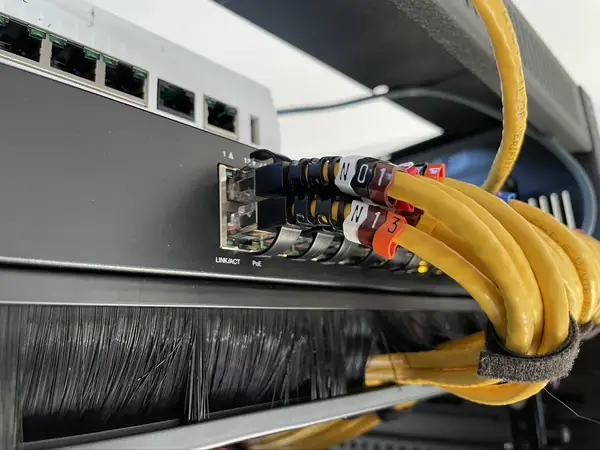 Tagged patch leads in the switch gathered with a hook and loop tie, seen close