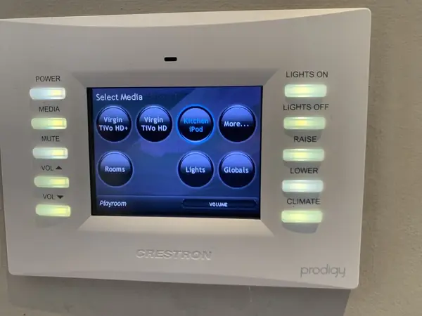 Prodigy touch panel from the old system on the wall, its Select Media screen offering TV, music, rooms and lights