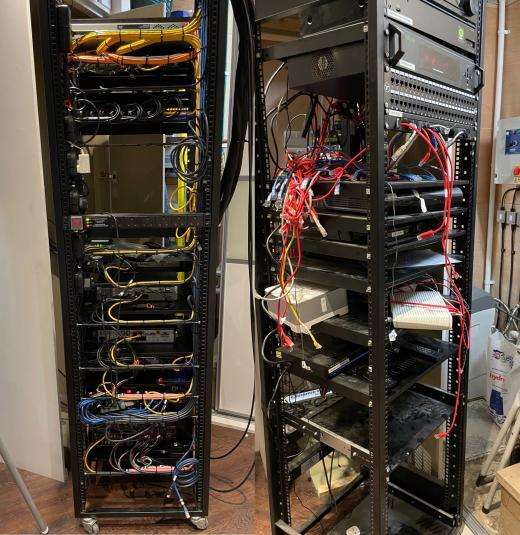 Two open equipment racks with untidy cabling, before a system rescue