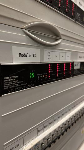Close up of a Crestron DIN rail dimmer in a lighting panel, labelled Module 13