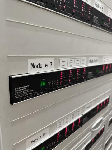 Crestron DIN rail dimmers in a lighting panel, each labelled with its module number