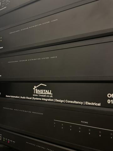 Close up of an equipment rack with a 1Install branded panel among the distribution units