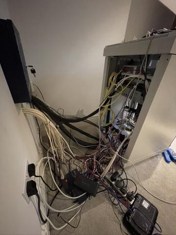 A tangle of cables and power supplies on the floor beside the equipment, before our rescue work