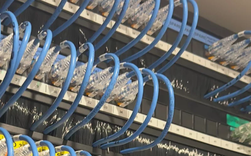 Where first fix wiring ends up: blue patch leads on numbered ports in a home rack, with room labels such as the office and the master bedroom, and spare ports marked