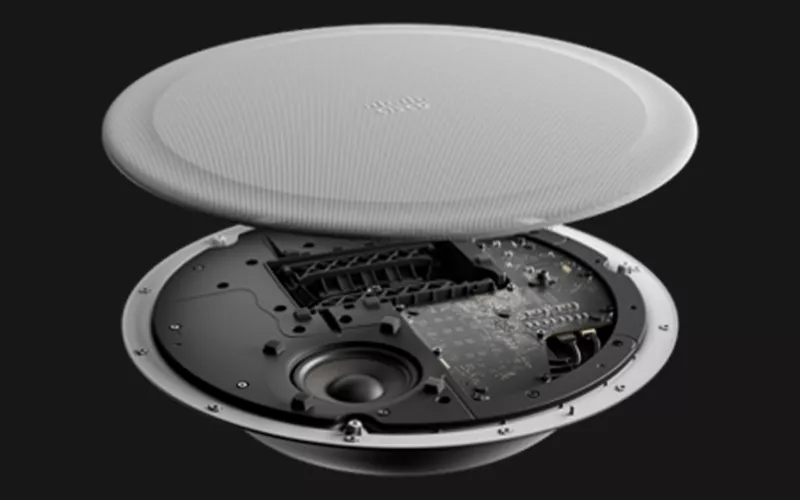 Cisco Ceiling Speaker Pro shown with its white grille lifted above the speaker driver and circuit board, announced by Cisco alongside its Cisco Google Meet news
