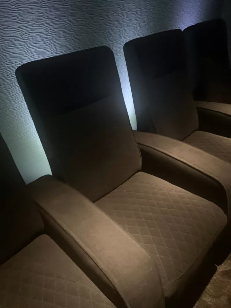 Recliner with diamond quilted cushions and pale light on the textured wall behind it