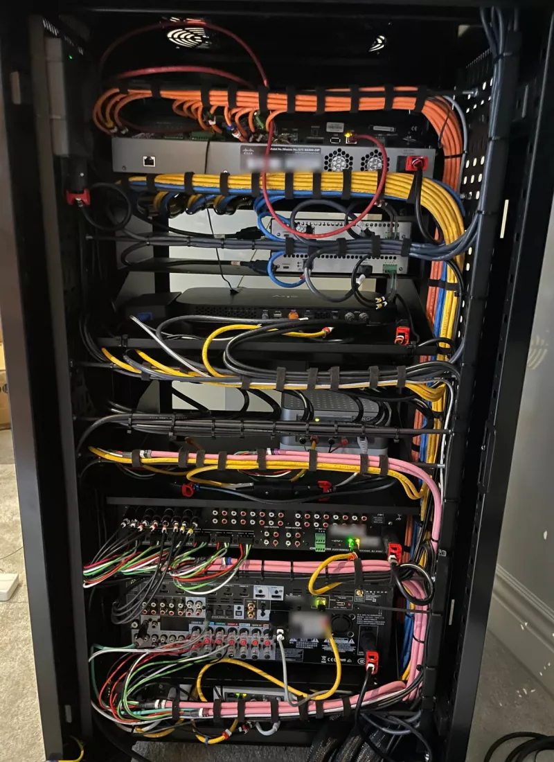 Rear of the rack with the cables grouped by colour and strapped: the Cisco switch at the top, then a Sky box, a Sonos unit, a Crestron audio unit and an AV receiver