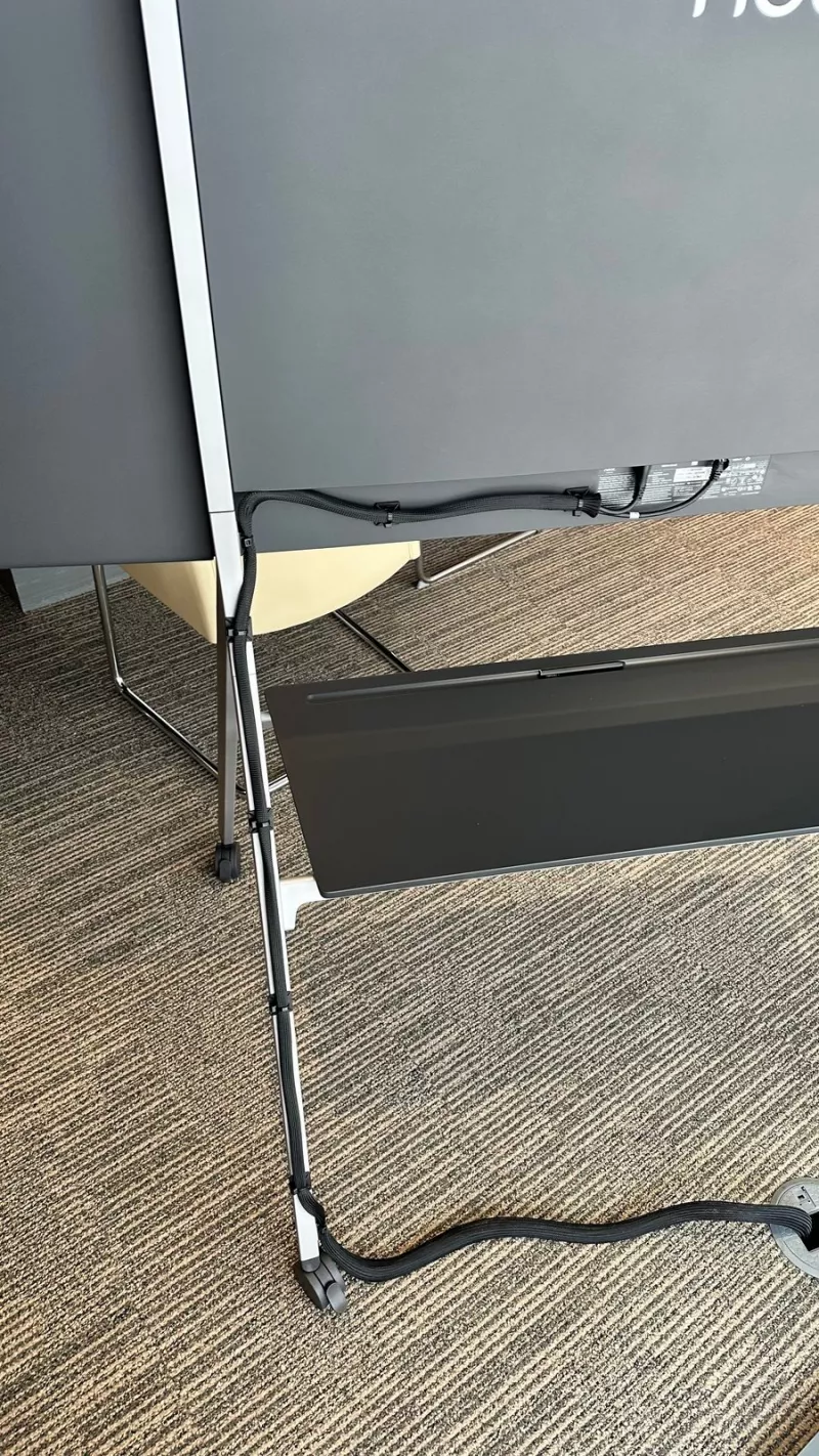 Neat Board stand leg wrapped in a black cable sleeve running to the floor