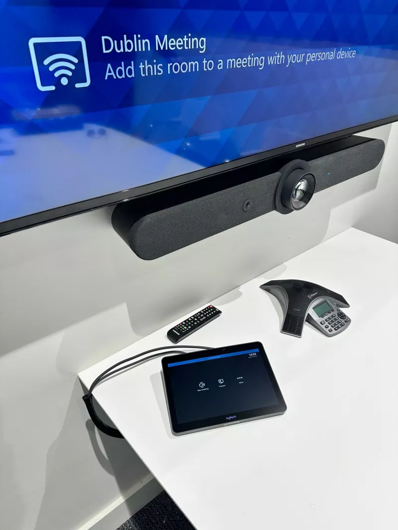 Closer in: the Logitech bar under the screen, and the Tap touch controller beside a speakerphone on the tabletop