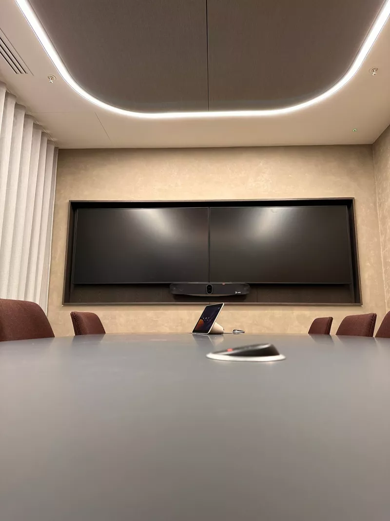 Meeting room AV installation in London: twin displays side by side above a Poly video bar, with a touch controller on the table