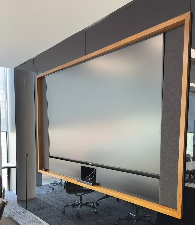 A large display framed in timber with grey felt panels at each side, set into a black glass wall
