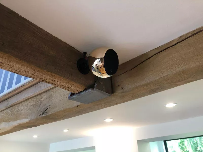 Round speaker fixed to an oak ceiling beam