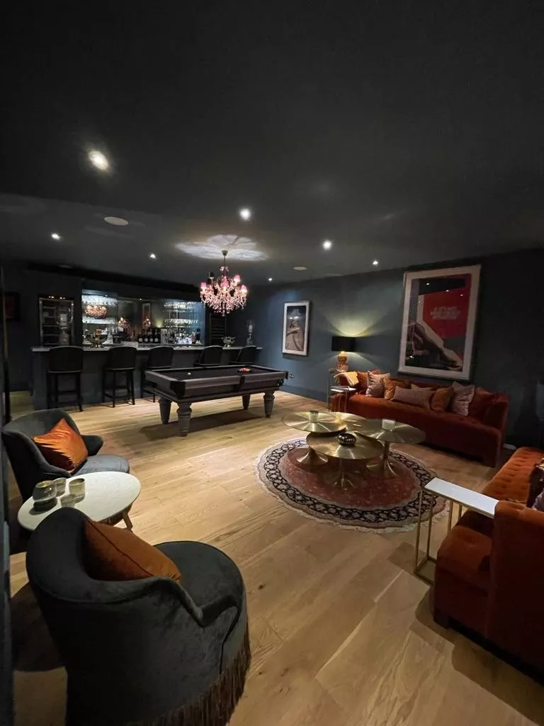 Games room with a bar, pool table and chandelier