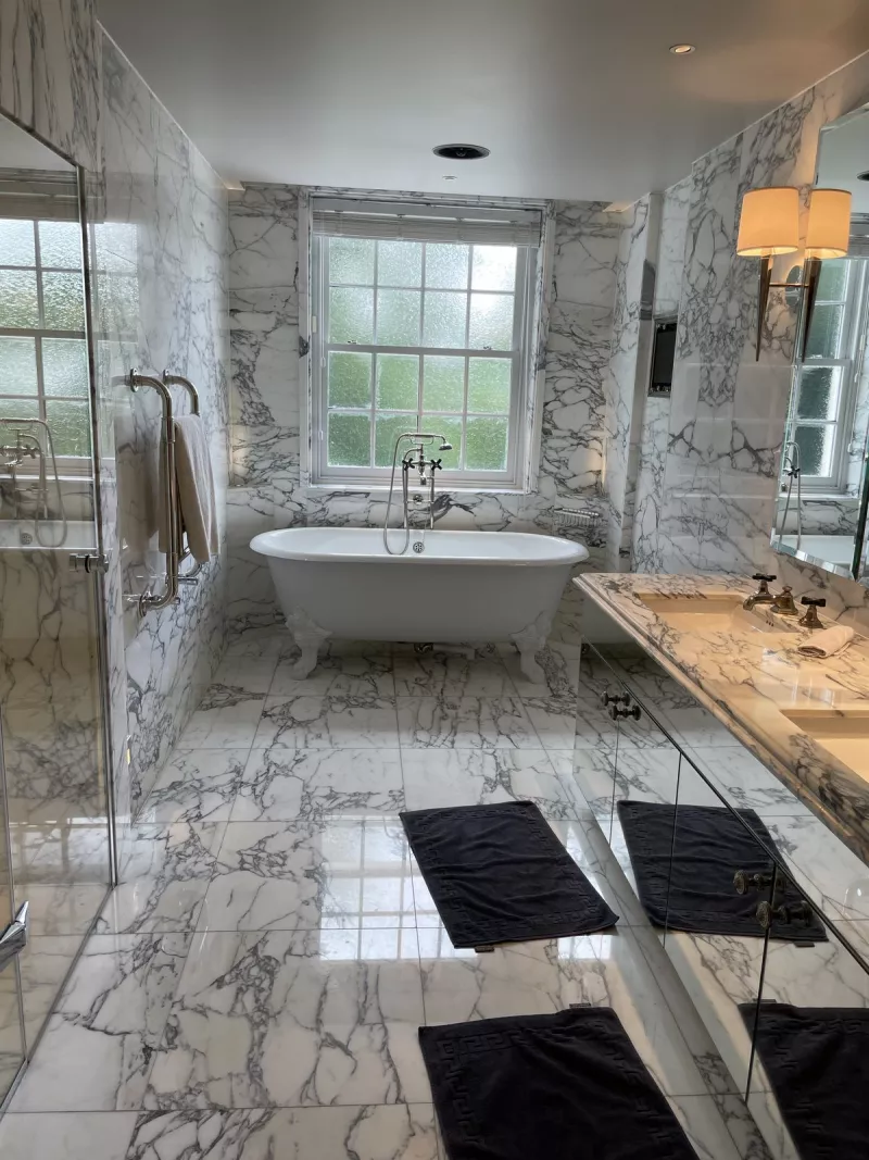 Marble bathroom with a freestanding bath and wall lights
