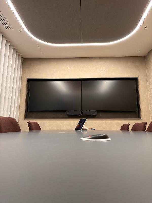 Meeting room AV installation in London: twin displays side by side above a Poly video bar, with a touch controller on the table