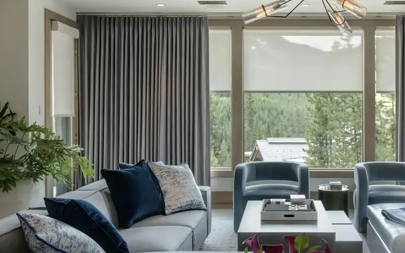 Living room with full length grey curtains framing a large window