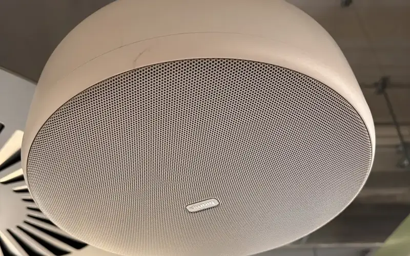 Round ceiling mounted speaker unit with a fine metal grille