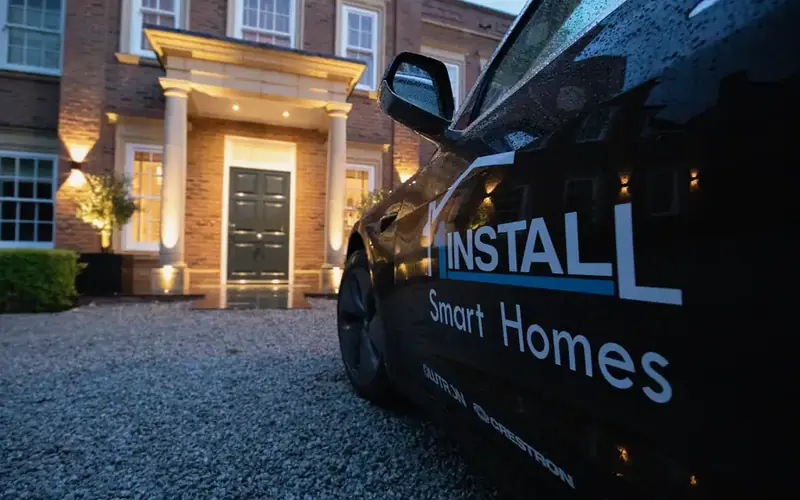 1Install branded vehicle on a gravel drive in front of a brick house with a lit entrance